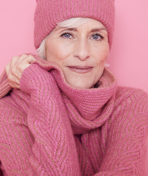 Matching hat, scarf and jumper in pink on a lady who looks wrapped warm and wrapped up. 