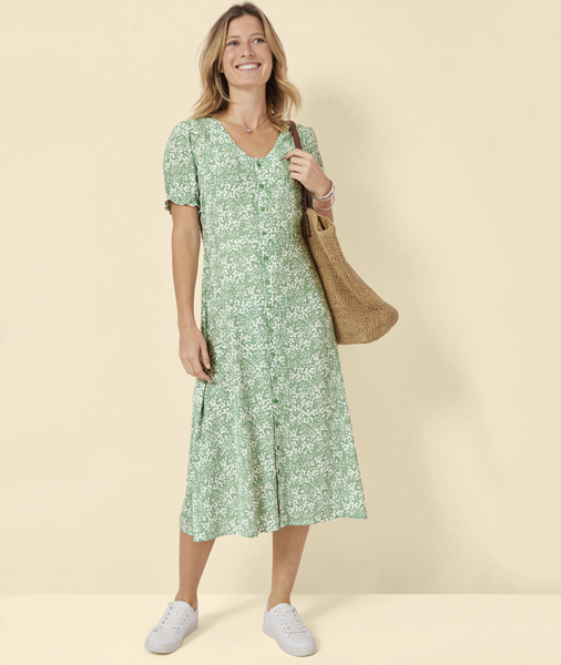 Woman wearing green floral dress with trainers
